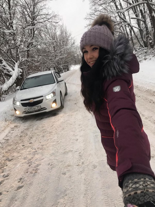 Стильная брюнетка в зимней фотосессии с автомобилем