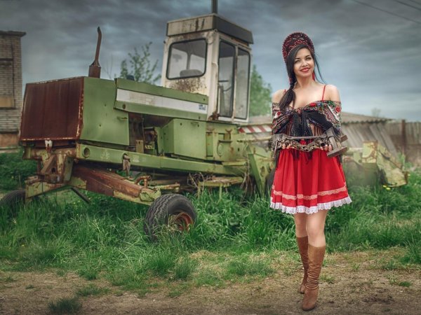 Привлекательная сельская девушка на тракторе с формами