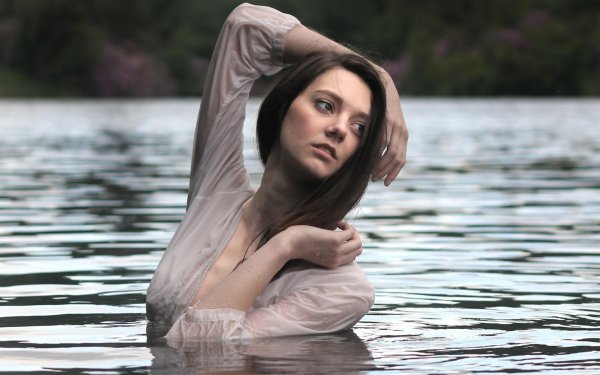 Девушка в воде в мокрой рубашке