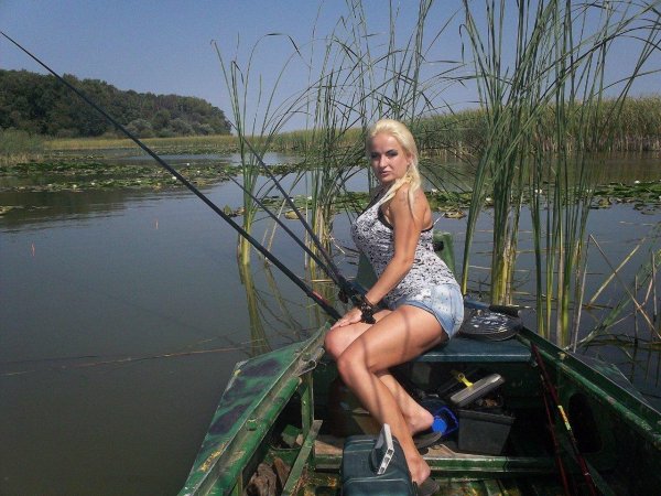 Очаровательная красавица наслаждается летней рыбалкой
