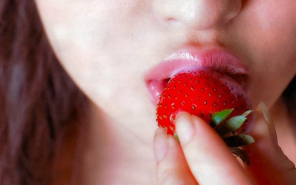 Соблазнительные губы девушки с клубникой