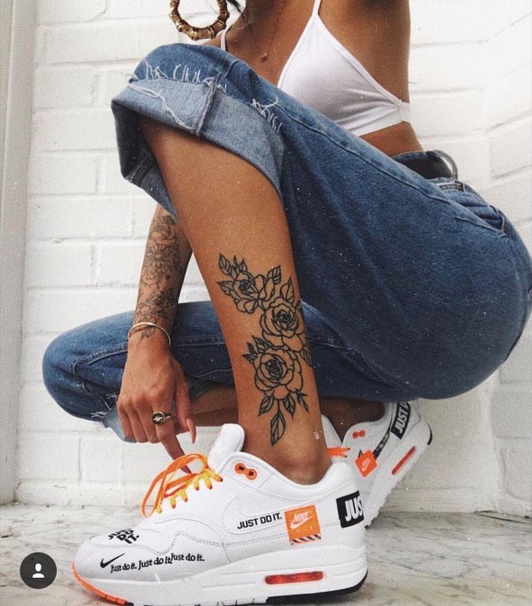 Спортивные Nike в татуировках на женских ногах