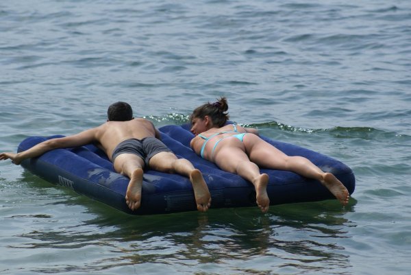 Очаровательная девушка отдыхает на морском матрасе