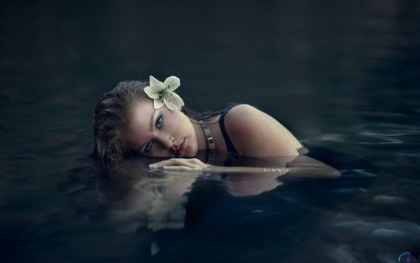 Девушка в воде в привлекательной фотосессии с сексуальными мокрыми позами