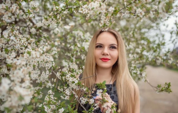 Девушка среди цветущих яблонь весной
