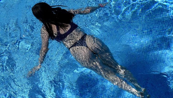 Соблазнительная девушка плавает в бассейне под водой привлекательно